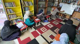 Ibu rumah tangga belajar menulis dan berhitung saat kegiatan gerakan berantas buta aksara di Taman Bacaan Masyarakat (TBM) Lentera Pustaka, Bogor, Minggu (2/5/2021). Lebih dari dua setengah tahun, TBM Lentera Pustaka mengajarkan puluhan ibu-ibu yang buta aksara. (merdeka.com/Arie Basuki)