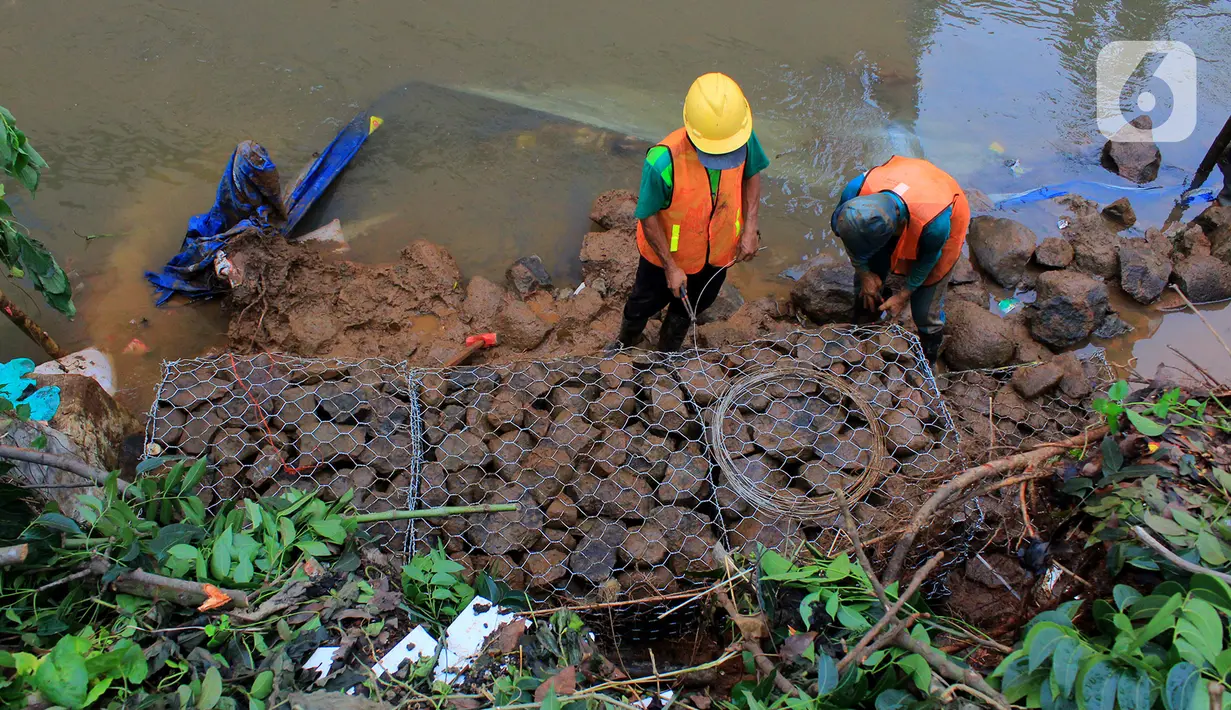 Pekerja memasang bronjong untuk menahan longsor susulan di Jalan Raya Tanah Baru, Depok, Jawa Barat, Kamis (9/1/2020). Sebelumnya, beberapa titik sepanjang Jalan Raya Tanah Baru mengalami longsor akibat hujan deras yang melanda. (merdeka.com/Magang/Muhammad Fayyadh)