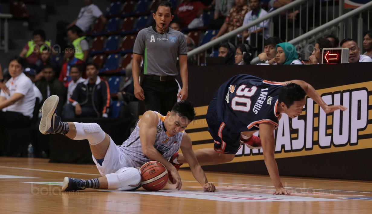 Pebasket Pelita Jaya,Prawiro Xaverius (kiri) jatuh saat berebut bola dengan pemain Satya Wacana, Cassiopeia Manuputy pada laga Perbasi Cup 2017 di Sports Mall, Kelapa Gading, Jakarta, (06/11/2017). Pelita Jaya menang 92-46. (Bola.com/Nick Hanoatubun)