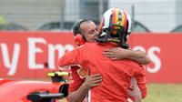 Pebalap Ferrari, Sebastian Vettel memeluk anggota timnya setelah finis di posisi terdepan dalam kualifikasi F1 GP di Sirkuit Hockenheim, Jerman, Sabtu (21/7). Vettel menorehkan waktu tercepat 1 menit 11,212 detik. (AP Photo/Jens Meyer)