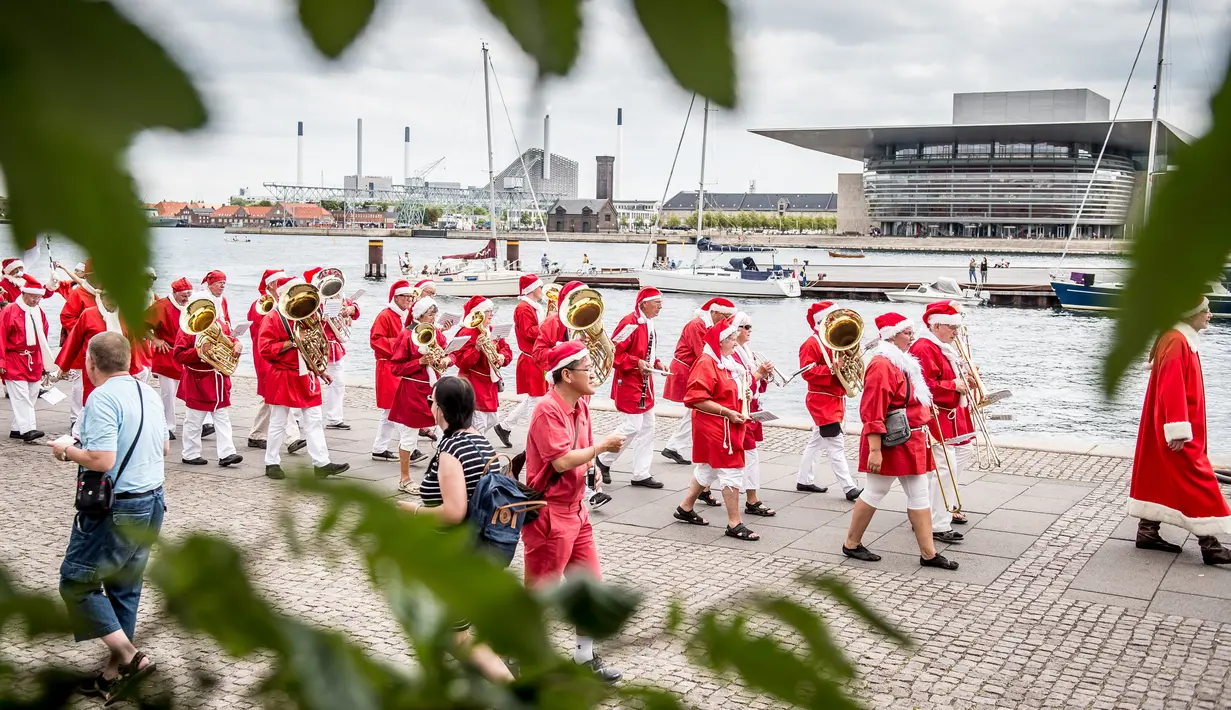 Santa claus mengikuti pawai yang merupakan bagian dari Kongres Dunia Sinterklas di Kopenhagen, Denmark, Senin (23/7). Kongres tersebut selalu diselenggarakan di musim panas saat para Sinterklas sedang libur. (Mads Claus Rasmussen/Ritzau Scanpix /AFP)