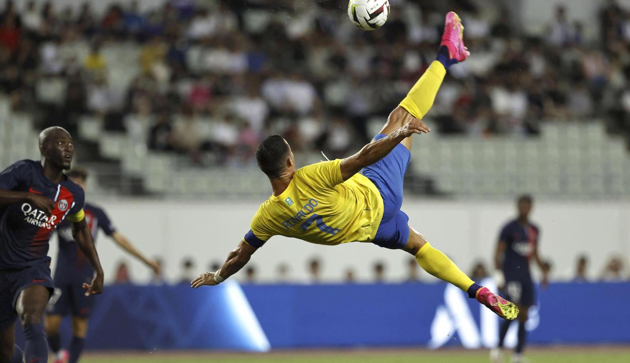 Pemain Al Nassr, Cristiano Ronaldo (kanan), melakukan aksi akrobatik sambil menendang bola ke gawang PSG dalam pertandingan uji coba yang berlangsung di Nagai Stadium, Osaka, Selasa (25/7/2023). (AFP/Paul Miller)