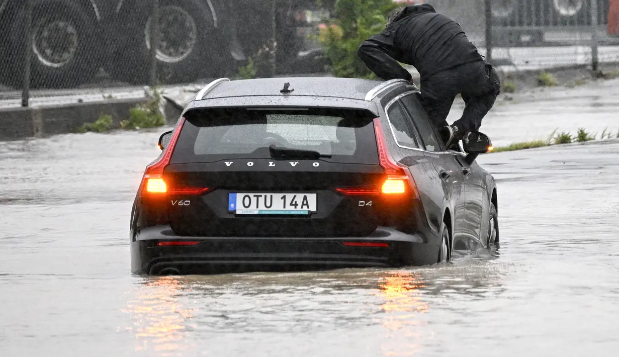 Di Swedia tengah, sebuah kereta tergelincir sebagian karena tanggul di bawah rel telah hanyut. Tiga orang luka ringan. (Johan Nilsson/TT News Agency via AP)