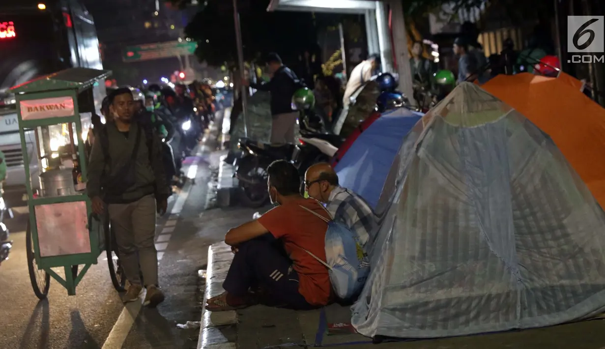 Pencari suaka duduk-duduk di luar tenda di atas trotoar depan Masjid Ar-Rayan, Jalan Kebon Sirih, Jakarta, Jumat (5/7/2019). Para pencari suaka ini membangun tenda-tenda dan meminta kepastian perlindungan dari UNHCR . (Liputan6.com/Helmi Fithriansyah)