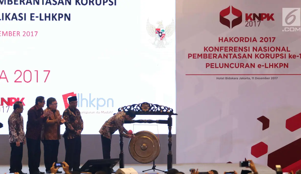 Presiden Jokowi (kanan) didampingi Ketua KPK, Agus Rahar (kedua kanan) memukul gong saat memperingati hari Antikorupsi Dunia di Jakarta, Senin (11/12). (Liputan6.com/Angga Yuniar)