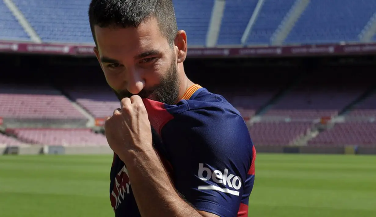 Arda Turan, pemain asal Turki yang direkrut Barcelona dari Atletico Madrid sebesar 41 juta euro diperkenalkan secara resmi kepada publik dalam suatu acara di Camp Nou, Barcelona. Jumat (10/7/2015). (AFP/Lluis Gene)