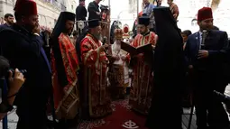 Patriark Teofilos III dari Yerusalem saat melakukan ritual cuci kaki tradisional di depan Gereja Makam Suci, Yerusalem (5/4). Ritual ini dilakukan setiap tahun pada Maundy atau Kamis Suci. (AFP Photo/Gali Tibbon)