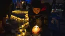 Orang-orang menyalakan lilin membentuk peta Ukraina, untuk mengenang nyawa yang hilang, di depan monumen Taras Shevchenko, di Lviv, Ukraina barat, Selasa malam (5/4/2022). Warga Ukraina berkumpul untuk momen menghormati nyawa yang hilang dalam perang. (AP Photo/Nariman El- Mofty)