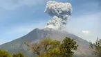 Asap bercampur abu vulkanis keluar dari kawah Gunung Agung terlihat dari desa Tulamben, Karangasem, Bali, Selasa (3/7). Pagi ini, Gunung Agung kembali meletus disertai abu vulkanik setinggi 2.000 meter di atas puncak. (AFP/SONNY TUMBELAKA)