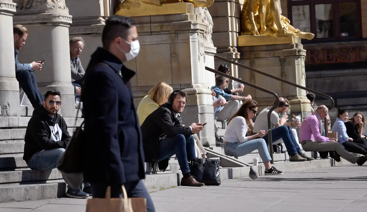 Orang-orang duduk di tangga Royal Dramatic Theatre dengan menjaga jarak di Stockholm, Rabu (22/4/2020). Swedia belum memberlakukan lockdown, namum pemerintah memberikan tanggung jawab yang besar kepada penduduknya untuk membantu mengurangi penyebaran virus corona. (Janerik Henriksson / TT via AP)