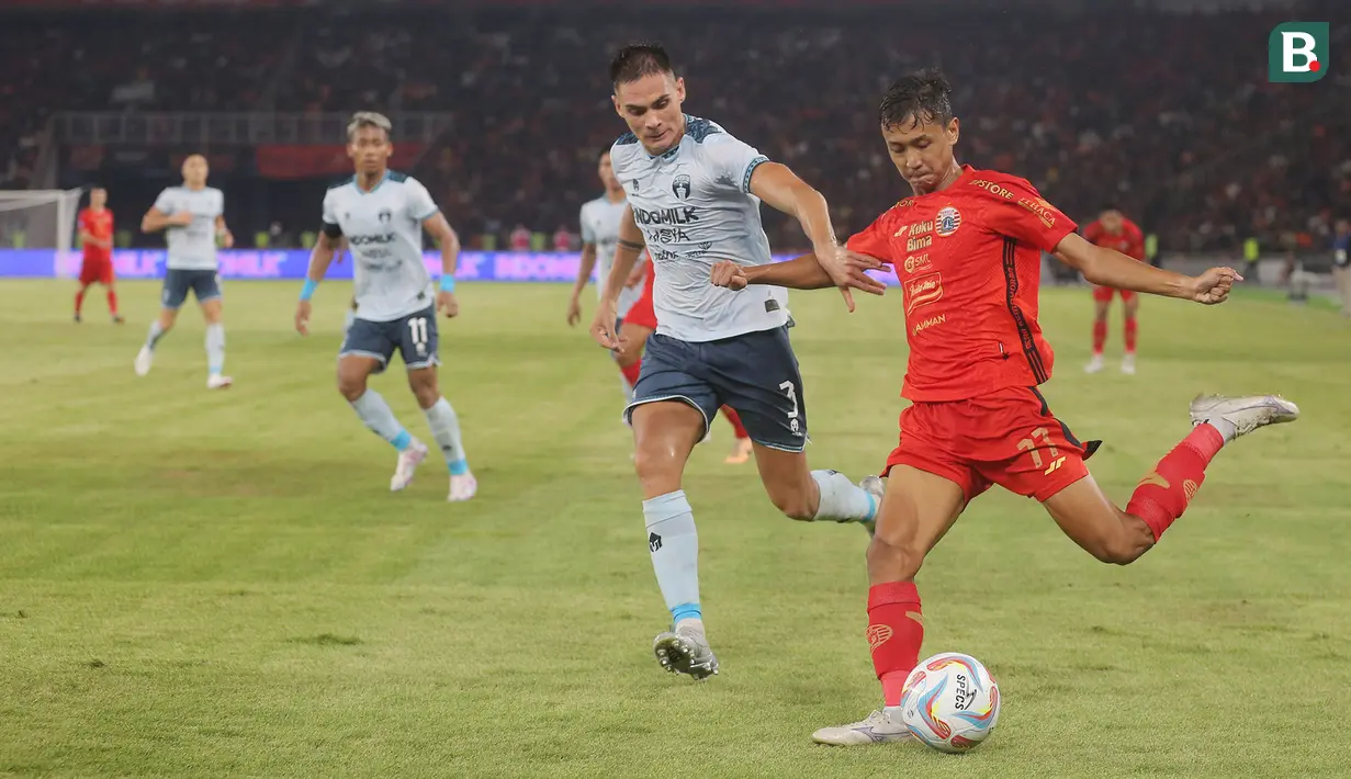 Pemain Persija Jakarta, Donny Tri Pamungkas (kanan), menendang bola dibayangi pemain Persita Tangerang, Christian Mangaron Rontini dalam pertandingan pekan ke-21 BRI Liga 1 2023/2024 yang berlangsung di Stadion Utama Gelora Bung Karno, Jakarta, Minggu (3/12/2023) malam WIB. (Bola.com/M Iqbal Ichsan)