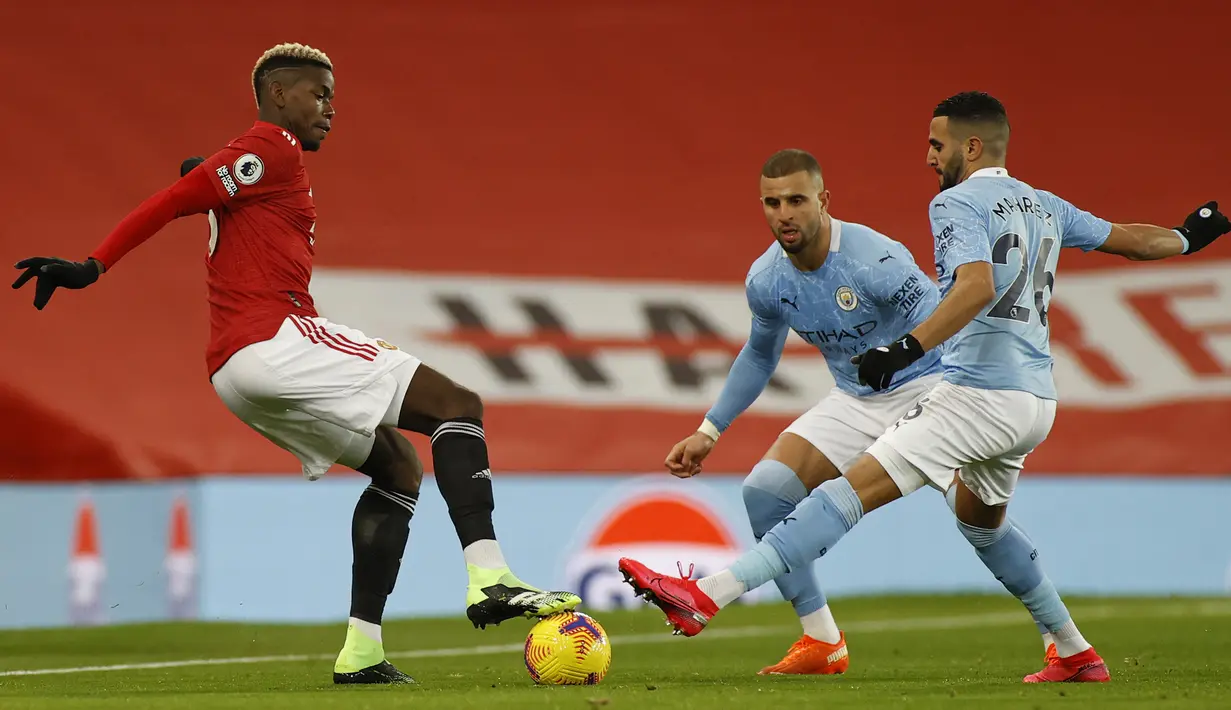 Gelandang Manchester United, Paul Pogba (kiri) dijaga dua pemain Manchester City, Riyad Mahrez (kanan) dan Kyle Walker, dalam laga lanjutan Liga Inggris 2020/21 pekan ke-12 di Old Trafford Stadium, Sabtu (12/12/2020). Manchester United bermain imbang 0-0 dengan Manchester City. (AFP/Phil Noble/Pool)