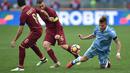 Pemain Lazio, Ciro Immobile (kanan) dihadang dua pemain AS Roma, Daniele De Rossi (tengah) dan Diego Perotti pada laga Derby della Capitale di Olympic Stadium, Roma, Italia, (4/12/2016). AS Roma menang 2-0.  (AFP/Alberto Pizzoli)
