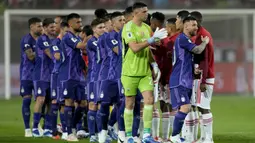 Para pemain Timnas Argentina (kiri) menyalami para pemain Peru sebelum dimulainya laga Kualifikasi Piala Dunia 2026 Zona Conmebol di National Stadium, Lima, Peru, Rabu (18/10/2023) pagi WIB. (AP Photo/Martin Mejia)