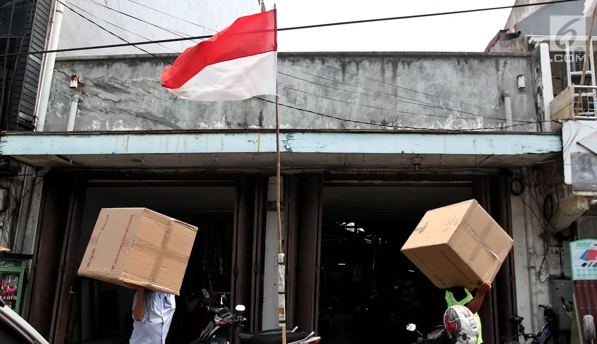 Pekerja membawa barang dagangan di pusat perbelanjaan Kawasan Pinangsia Glodok, Jakarta Barat, Selasa (22/8). Kawasan ini merupakan sentra ekonomi yang menyediakan berbagai kebutuhan. (Liputan6.com/Johan Tallo)