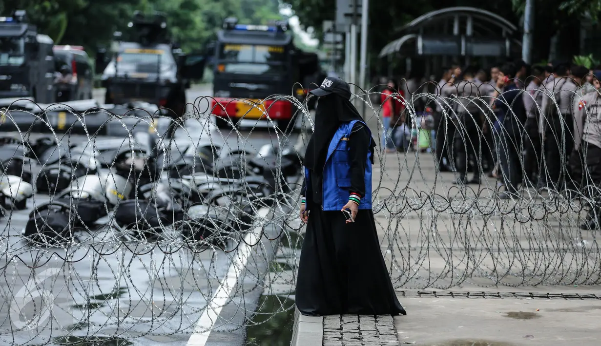 Peserta aksi berada di dekat kawat berduri saat aksi bela islam 313 di Jalan Merdeka Barat, Jakarta, (31/3). Mereka menuntut kepada Presiden Jokowi agar melaksanakan undang-undang dengan mencopot gubernur terdakwa, Ahok. (Liputan6.com/Faizal Fanani)