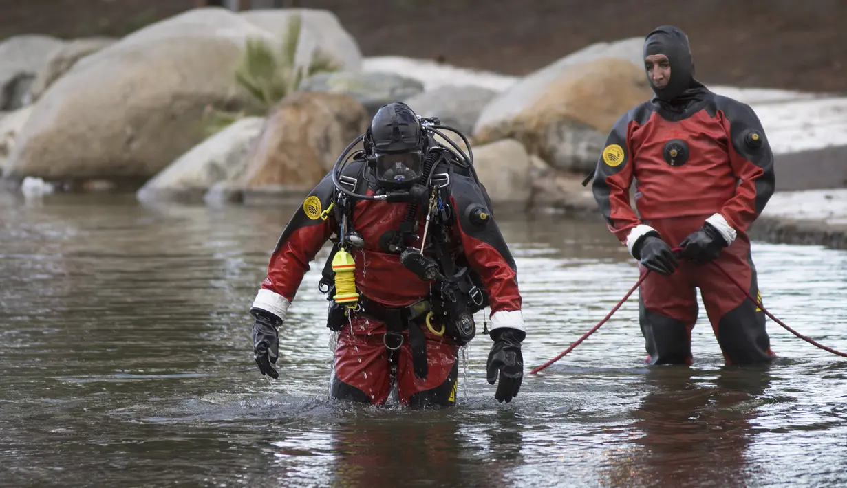 Petugas mencari bukti pembantaian di San Bernardino yang mungkin telah dilemparkan ke Seccombe Lake, Jumat (11/12/2015). Warga AS, Syed Farook, 28,  istrinya menyerbu Inland Regional Centre dan menewaskan 14 orang. (AFP Photo /Guillaume Meyer)