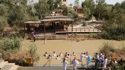 Suasana saat umat Kristen mengikuti prosesi pembaptisan di Sungai Yordan, Jericho, Palestina, Jumat (13/9/2019). Lokasi ini diyakini sebagai tempat pembaptisan Yesus Kristus oleh Yohanes Pembaptis. (HAZEM BADER/AFP)