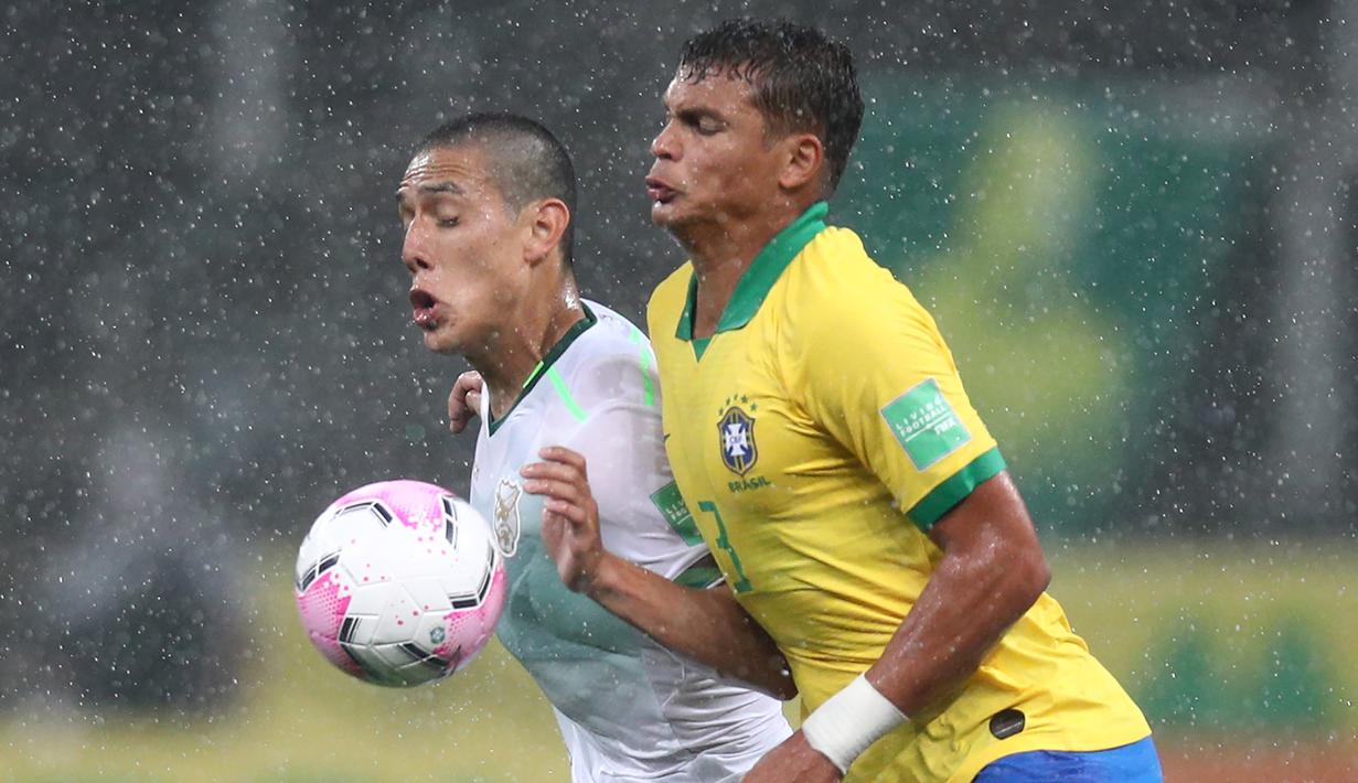 Bek Brasil, Thiago Silva, berebut bola dengan penyerang Bolivia, Cesar Menacho, pada laga kualifikasi Piala Dunia 2020 di Corinthians Arena, Sabtu (10/10/2020) pagi WIB. Brasil menang 5-0 atas Bolivia. (AFP/Buda Mendes/pool)