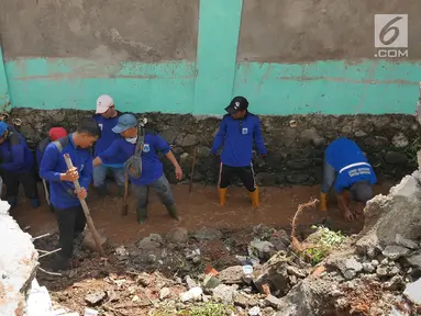 Petugas gabungan membersihkan puing-puing longsoran di Perumahan Pesona Kalisari, Pasar Rebo, Jakarta, Selasa (27/11). Ekskavator turut dikerahkan untuk membersihkan puing-puing dan tumpukan tanah yang menutupi jalanan. (Liputan6.com/Herman Zakharia)