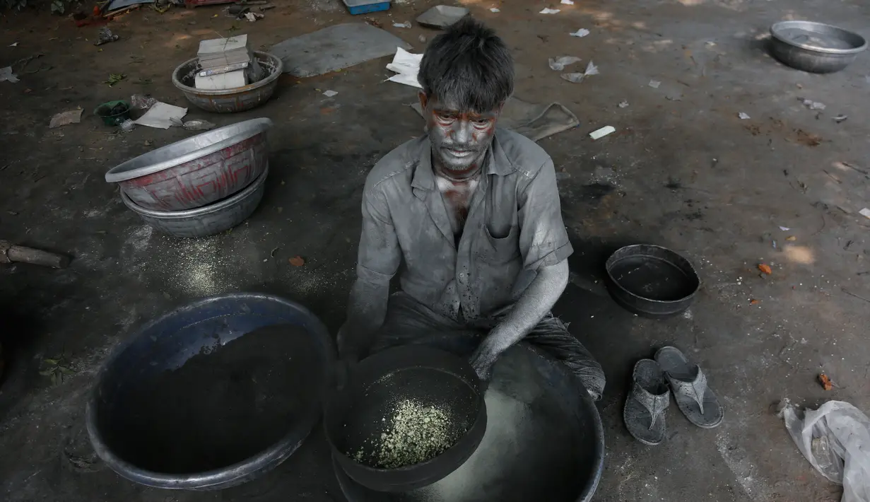 Seorang pria India meracik bubuk mesiu untuk membuat petasan yang digunakan dalam festival Diwali di Ahmadabad, India (27/9). Menjelang perayaan Diwali, sejumlah produsen petasan di India dibanjiri pesanan. (AP Photo/Ajit Solanki)