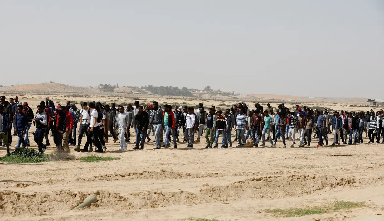 Migran Afrika berkumpul berjalan menuju Penjara Saharonim untuk melakukan aksi, Israel (22/2). Otoritas Israel telah memberitahukan para migran Afrika bahwa mereka punya waktu hingga Maret mendatang untuk meninggalkan Israel. (AFP Photo/Menahem Kahana)