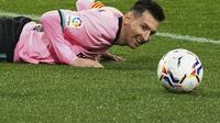 Megabitang Barcelona, Lionel Messi berbaring di lapangan saat menghadapi Valladolid pada laga pekan ke-15 Liga Spanyol di Stadion Jose Zorrilla, Selasa (22/12/2020). Lionel Messi resmi melewati rekor Pele saat membantu Barcelona menggulung Valladolid 3-0 dalam laga tersebut. (Cesar Manso/Pool via AP