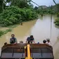 Warga terlihat dievakuasi menggunakan alat berat dari daerah di mana jalan saat ini terendam banjir di Sementeh, dekat Lanchang di negara bagian Pahang Malaysia (6/1/2021). Puluhan orang dievakuasi saat Pahang dilanda gelombang kedua banjir. (AFP/Mohd Rasfan)