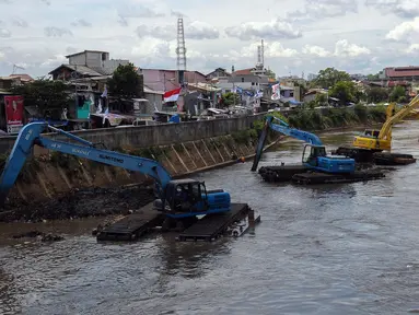 Ekskavator mengeruk endapan material lumpur pada aliran Kali Ciliwung di Jakarta, Selasa (16/1/2023). Proyek ini dilakukan untuk mengurangi pendangkalan kali dan bagian dari program pencegahan penanggulangan banjir yang sudah masuk musim penghujan. (merdeka.com/Imam Buhori)