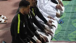 Para pemain Timas Qatar salat berjamaah sebelum sesi latihan mereka di Abu Dhabi (31/1). Qatar harus melewati Korea Selatan sebelum menginjakkan kakinya di final Piala Asia 2019. (AFP Photo/Roslan Rahman)