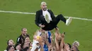 Para pemain Maroko melakukan selebrasi dengan melemparkan pelatih Walid Reragui ke udara usai pertandingan melawan Kanada pada grup F Piala Dunia 2022 di Stadion Al Thumama di Doha, Qatar, Kamis (1/12/2022). Hasil ini membuat Maroko lolos ke babak 16 besar Piala Dunia 2022 dengan status juara Grup F dengan perolehan tujuh poin. Sementara runner up jadi milik Kroasia. (AP Photo/ Alessandra Tarantino)