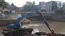 Eksavator amphibi digunakan untuk melakukan proses pengerukan endapan tanah di aliran Sungai Ciliwung, Jakarta, Selasa (28/7/2020). Pengerukan endapan ini untuk memperlancar aliran air Sungai Ciliwung serta upaya pencegahan banjir saat musim hujan. (Liputan6.com/Helmi Fithriansyah)