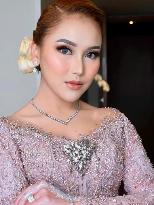 Dengan gaya rambut disanggul dan hiasan bunga, penampilan Ayu Ting Ting terlihat begitu cantik. Ibu satu anak itu bahkan melengkapi tampilannya dengan henna putih di tangannya. (Instagram/kriznafahrezi).