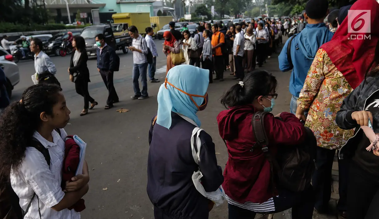 Masyarakat mengantre untuk menaiki bus Transjakarta di depan Cibubur Junction, Jakarta, Senin (16/4). Aturan ganjil genap untuk kendaraan pribadi diujicobakan di Gerbang Tol Cibubur II hari, ini Senin 16 April 2018. (Liputan6.com/Faizal Fanani)