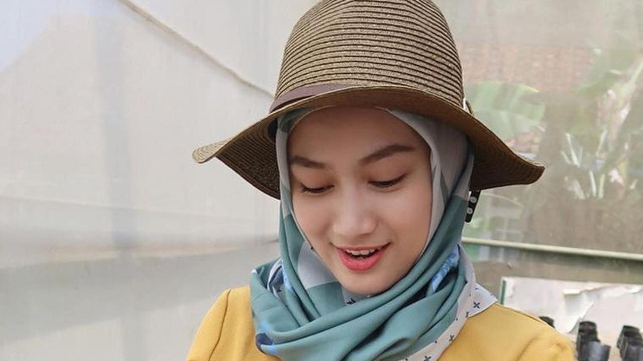 Melody berpose ketika sedang menanam bibit tomat momotaro dan memindahkannya ke dalam polibag.