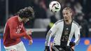 Bek Timnas Turki, Ferdi Kadioglu (kiri) berebut bola dengan gelandang Timnas Jerman, Leroy Sane pada laga uji coba internasional di Olympiastadion, Berlin, Minggu (19/11/2023) dini hari WIB. (AP Photo/Markus Schreiber)