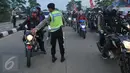 Petugas mengatur kendaraan yang terjebak kemacetan di jalan Lamaran, Karawang, Sabtu (2/7). Kemacetan tersebut terjadi akibat pemisahan jalur antara roda dua dengan roda empat untuk mengantisipasi jalur mudik Pantura. (Liputan6.com/Gempur M Surya)