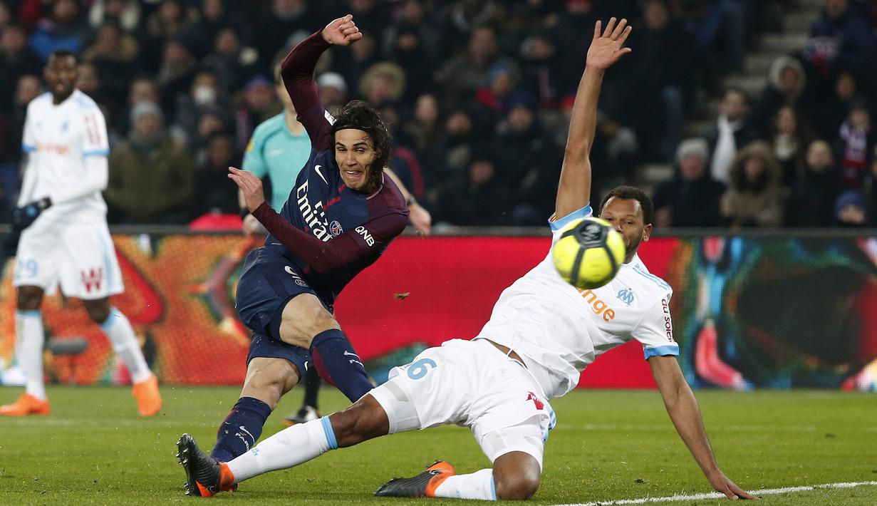 Edinson Cavani (kiri) melepaskan tembakan saat diadang pemain Marseille pada lanjutan Ligue 1 Prancis di Parc des Princes Stadium, Paris, (25/2/2018). PSG menang 3-0. (AP/Thibault Camus)