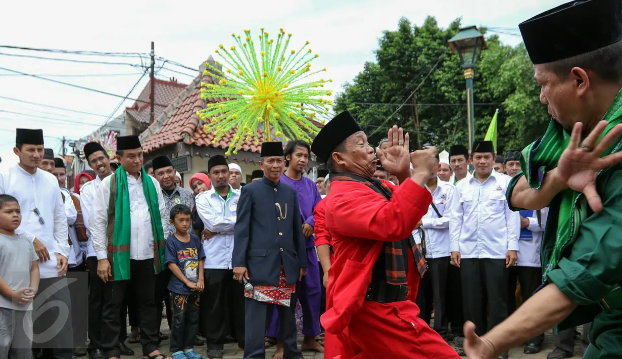 Tradisi palang pintu menyambut Yusril dan Sandiaga Uno saat tiba di Gebyar Budaya Betawi di Balai Rakyat Condet, Jakarta, Minggu (20/3/2016). Dua balon Gubernur DKI Jakarta tersebut menemui Rumpun Masyarakat Betawi. (Liputan6.com/Yoppy Renato)