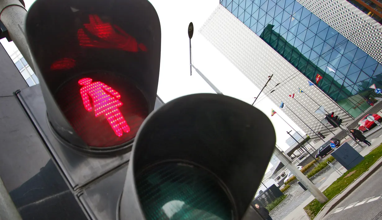 Lampu lalu lintas khusus pejalan kaki yang menampilkan simbol wanita di Vilnius, Lituania, Jumat (2/11). Hal itu untuk merayakan ulang tahun ke-100 wanita memperoleh pengakuan internasional dalam pemungutan suara di negara baltik. (Petras Malukas/AFP)
