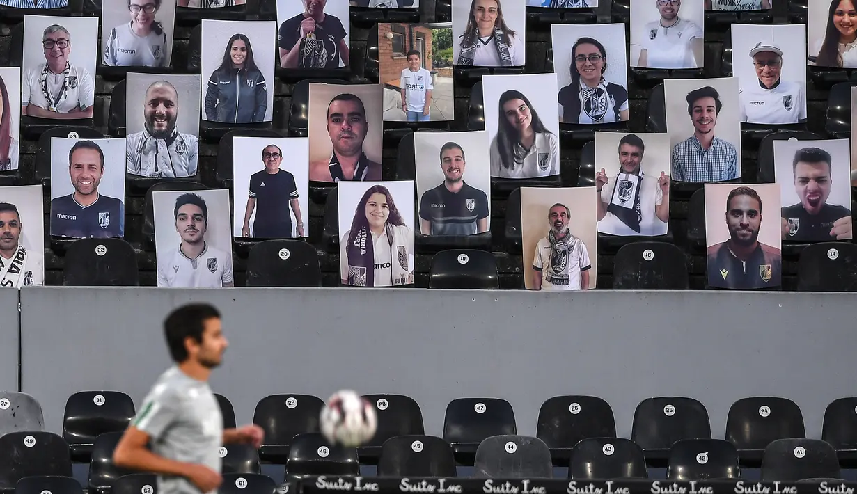 Foto-foto pendukung Vitoria Guimaraes mengisi kursi Stadion Dom Afonso Henriques, Guimaraes, Kamis (4/6/2020) waktu setempat. Kompetisi Liga Portugal dilanjutkan dengan aturan tanpa ada penonton di setiap pertandingan. (AFP/Hugo Delgado/pool)