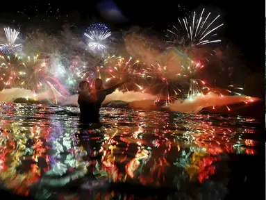 Pasangan saat menikmati kembang api yang meledak menghiasi langit di pantai Copacabana saat perayaan Tahun Baru 2016 di Rio de Janeiro, Brasil, (1/1/2016). (REUTERS/Ricardo Moraes)