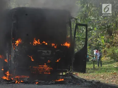 Sebuah bus pariwisata nopol AB 7536 AK terbakar pada ruas tol Jagorawi arah Bogor di KM 36, Bogor, kamis (25/7/2019). Bus kosong yang diawaki dua orang ini terbakar habis dengan api yang bersumber pada bagian AC bus. (merdeka.com/Arie Basuki)