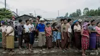 Dalam foto yang diambil pada 21 Mei 2021 ini, orang-orang menunggu untuk menerima kantung beras yang didistribusikan oleh Program Pangan Dunia (WFP) sebagai bagian dari upaya bantuan pangan untuk mendukung warga yang tinggal di komunitas miskin di pinggiran Yangon. (Foto: AFP / STR)