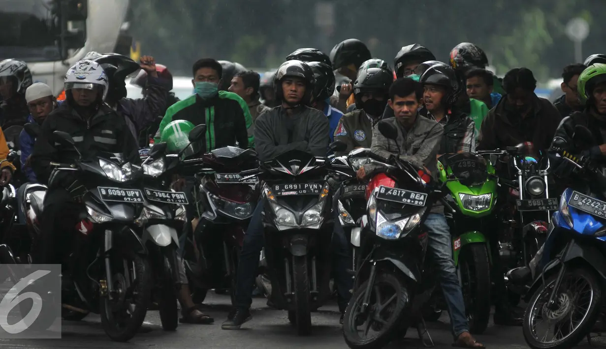 Pengendara sepeda motor berteduh di bawah flyover saat hujan turun, Jakarta, Rabu (13/7). Petugas kepolisian akan menerapkan tilang dengan denda maksimal Rp250.000 untuk pengendara yang berteduh di bawah flyover. (Liputan6.com/Gempur M Surya) 