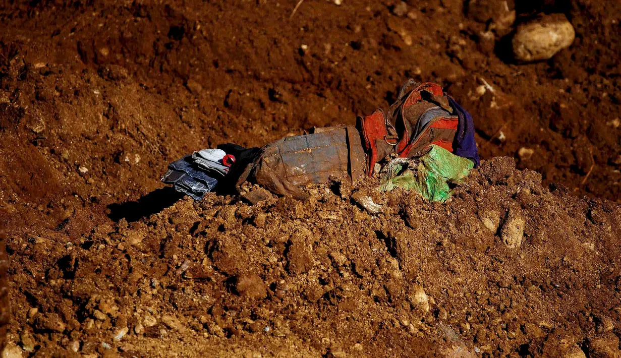 Tampak pakaian para korban longsor yang berada direruntuhan pasir selama pencarian korban di lokasi tambang Hpakant giok, Myanmar, (21/11). Diperkirakan masih ada ratusam korban yang belum ditemukan. (REUTERS/Stringer)