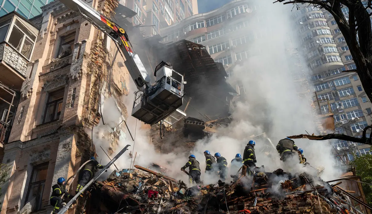 Petugas pemadam kebakaran bekerja setelah sebuah serangan pesawat tak berawak di gedung-gedung di Kyiv, Ukraina, Senin (17/10/2022).  Pesawat tak berawak menghantam sejumlah gedung ibu kota Ukraina pada Senin pagi ledakan tesebut menggema di seluruh Kyiv dan menimbulkan kepanikan sehingga orang-orang berlarian ke lokasi yang aman. (AP Photo/Roman Hrytsyna)