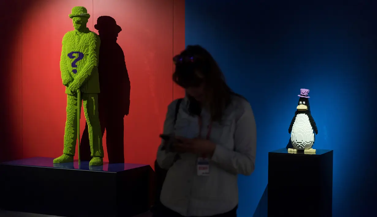 Seorang wanita berdiri dekat karakter pahlawan superhero DC yang dibuat dari Lego pada pameran Art of the Brick di La Vilette, Paris, Kamis (26/4). Tokoh superhero yang dibuat dengan Lego ini hasil karya seniman AS, Nathan Sawaya (AFP/Lionel BONAVENTURE)