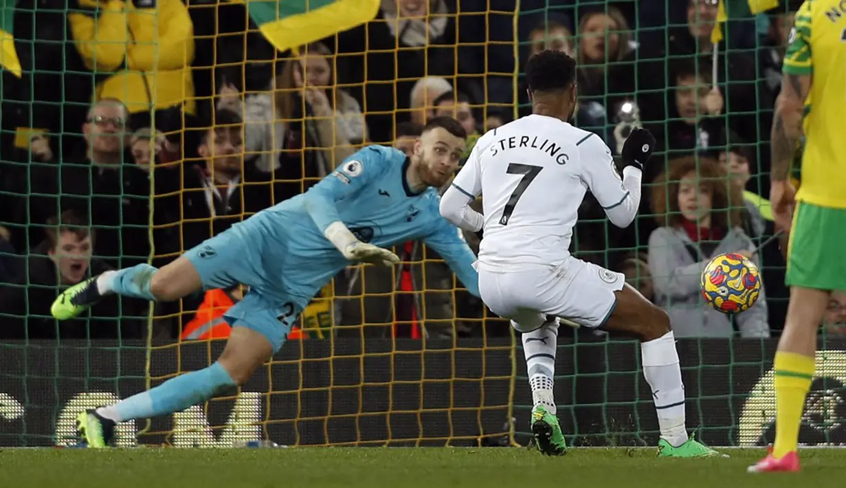 Pemain Manchester City Raheem Sterling melihat tendangan penaltinya diselamatkan oleh kiper Norwich City Angus Gunn pada pertandingan sepak bola Liga Inggris di Stadion Carrow Road, Norwich, Inggris, 12 Februari 2022. Manchester City menang 4-0. (Adrian DENNIS/AFP)