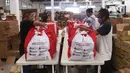 Pekerja sedang mengemas bantuan paket sembako dari Presiden Joko Widodo di Tangerang, Sabtu (9/6/2020).  Ribuan paket sembako tersebut akan didistribusikan kepada warga kurang mampu di wilayah Bodetabek guna mengurangi beban ekonomi mereka di tengah pandemi COVID-19. (Liputan6.com/Angga Yuniar)